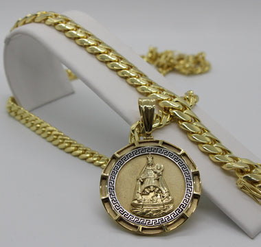 a picture of a cuban link chain and religious pendant 